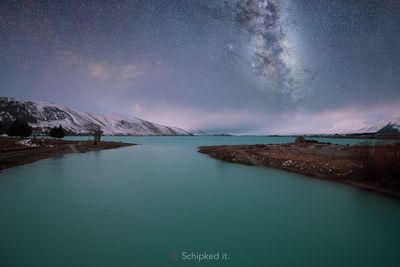 Scenic view of lake against sky at night