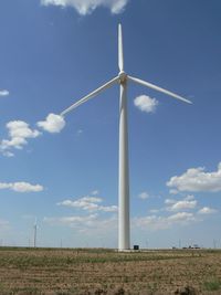 Low angle view of windmill on field against sky