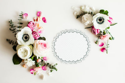 Directly above shot of pink roses on white table