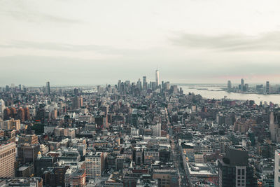 Aerial view of buildings in city against sky