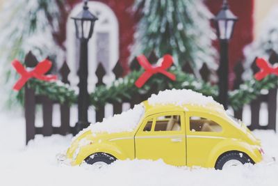 Close-up of yellow toy car on snow