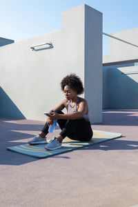 African american sportswoman browsing smartphone during break