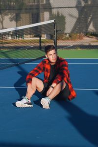 Man in flannel on bright colored tennis court