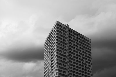 Low angle view of office building against cloudy sky