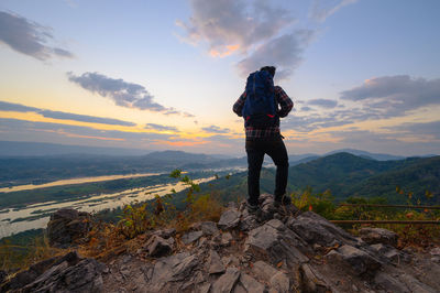 Hiker standing on the cliff watching the view of mekong river in morning