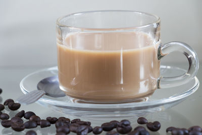 Close-up of coffee beans and cup on table