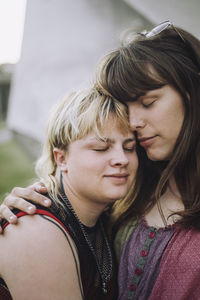 Young couple with eyes closed embracing each other