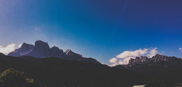 Scenic view of mountains against blue sky