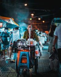 People standing on street at night