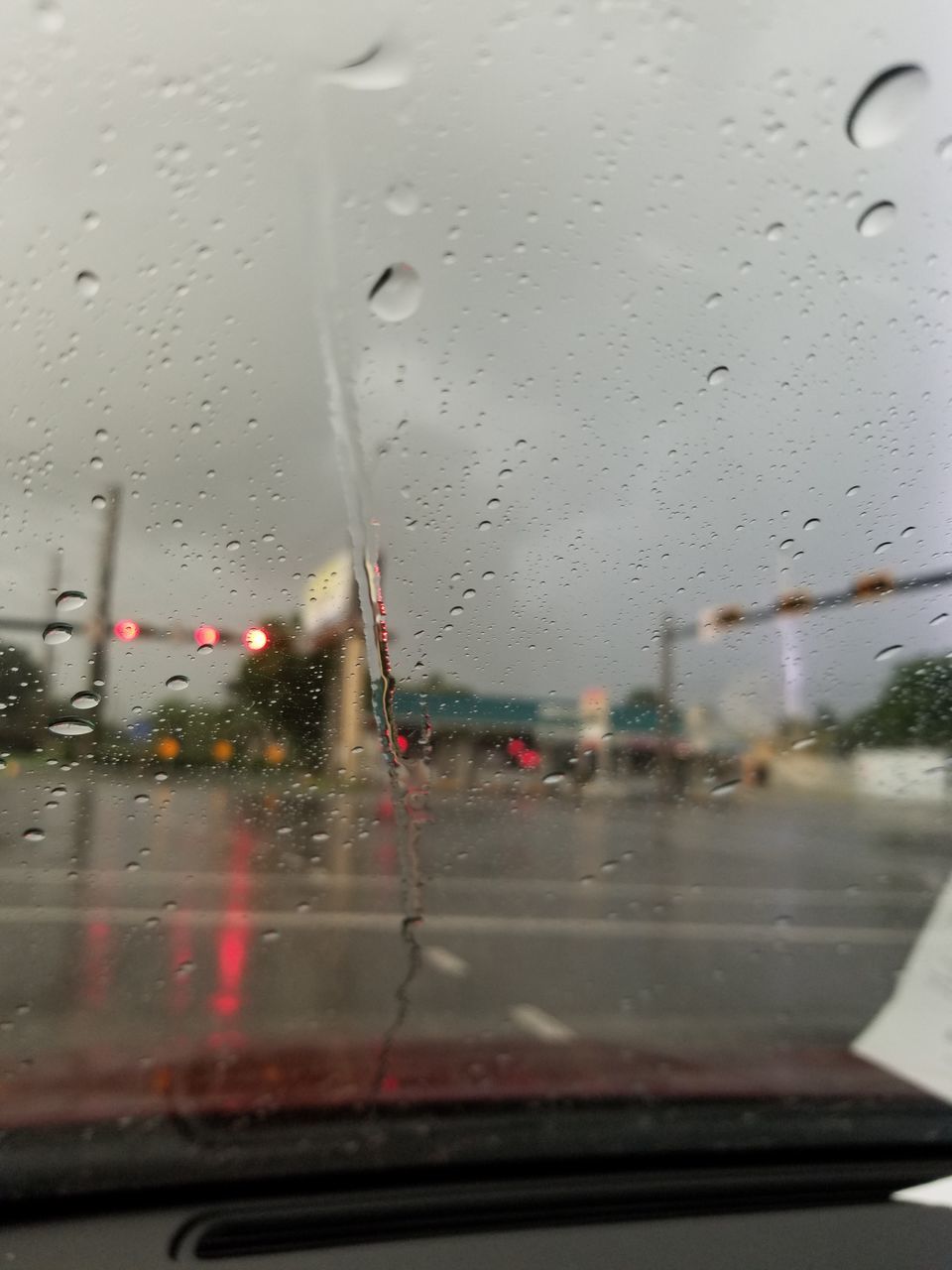 CARS ON ROAD SEEN THROUGH WET WINDSHIELD