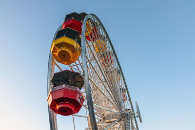 Low angle view of ferris wheel against blue sky