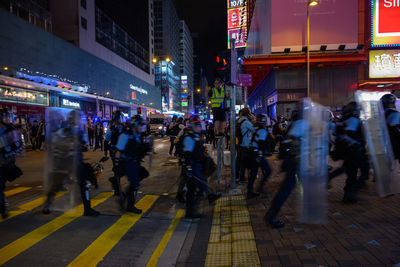 People walking on city street at night