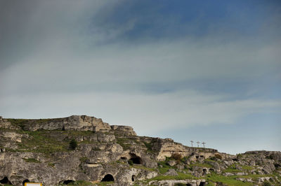 Low angle view of rocky mountain against sky