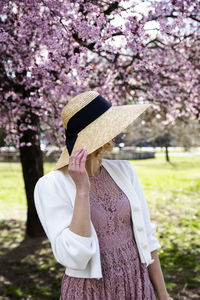 Low section of woman standing on cherry blossom