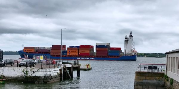 Commercial dock by sea against sky