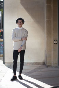 Full length portrait of man standing against wall