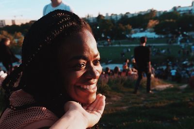 Close-up of smiling woman sitting against sky