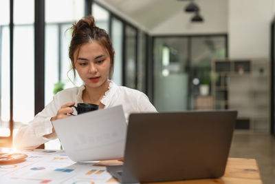 Businesswoman using laptop at table