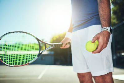Midsection of man playing tennis