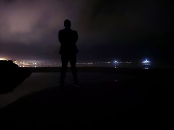 Rear view of silhouette man standing at night