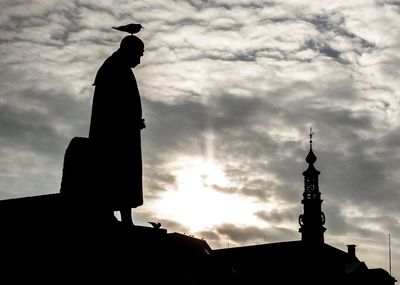 Low angle view of silhouette statue against sky