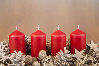 Close-up of red candles over beige background