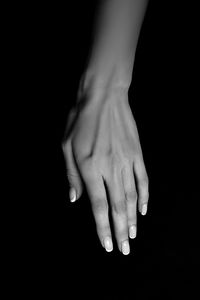 Close-up of woman hand over black background