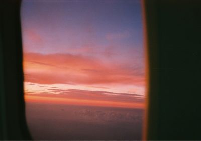 Scenic view of sea against sky during sunset seen through window