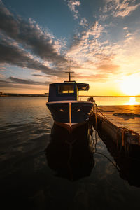 Boat moored in the port of taranto vecchia with the rising sun behind it