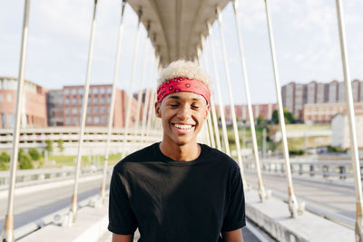 Handsome black boy with headscarf standing in the middle of the bridge