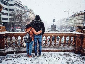 Rear view of people on snow covered city in winter