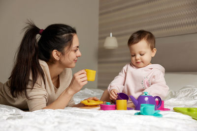 Mother playing with toy blocks at home