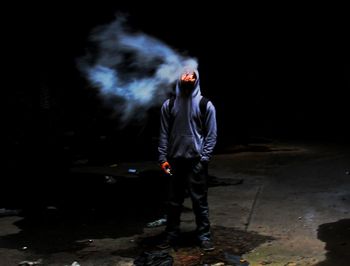 Full length of a man with umbrella standing at night