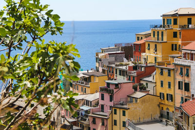 High angle view of buildings by sea against clear sky during sunny day