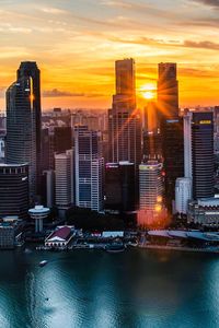 Modern buildings against sky during sunset in city