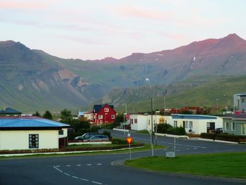 Houses by road against sky in city