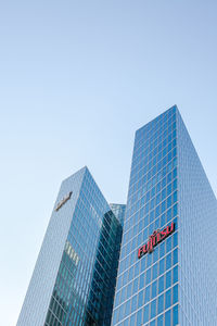 Low angle view of modern buildings against clear blue sky