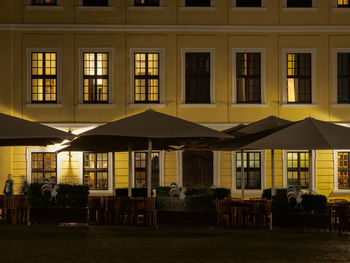 People in restaurant against building at night