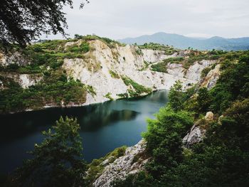 High angle view of river amidst mountains against sky