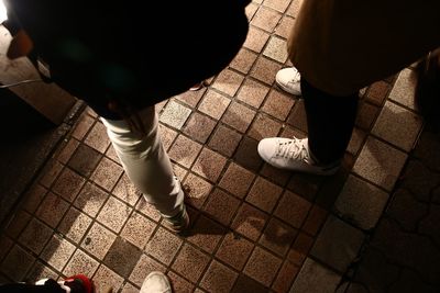 Low section of people standing on tiled floor