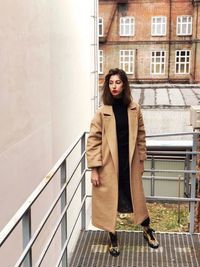 Portrait of woman standing in front of building
