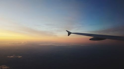 Airplane flying in sky during sunset