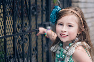 Portrait of cute girl standing by gate