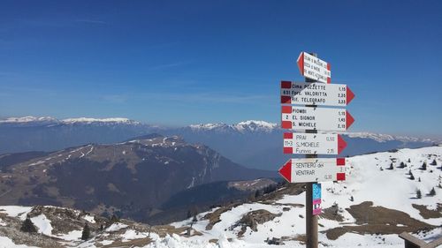 Roadsigns against snowed rocky landscape