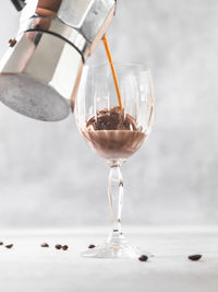 Close-up of wineglass with ice cream and coffee affogato on table