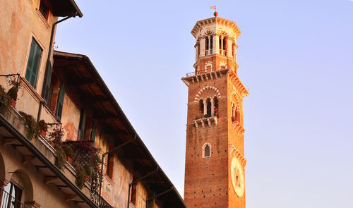 Low angle view of clock tower amidst buildings against sky