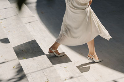 Low section of woman walking on street