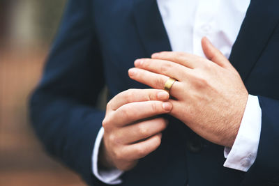 Midsection of man wearing ring
