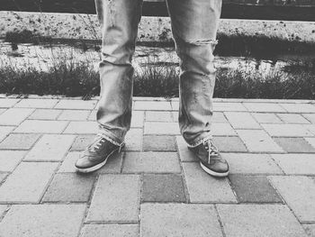 Low section of man standing on cobblestone