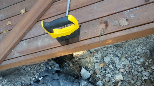 High angle view of wood on rock against wall